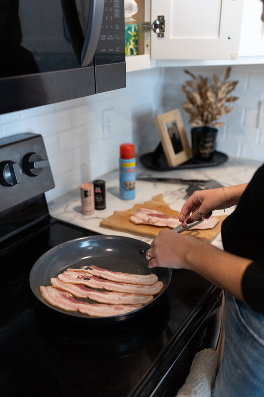 Women cooking bacon on stovetop