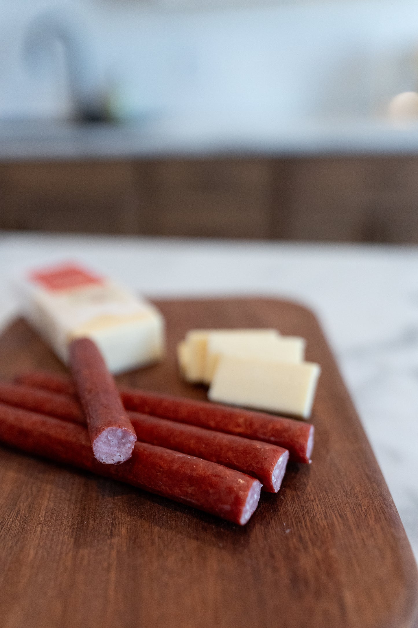 Just Pork's Ham and Cheese Sticks laying on cutting board