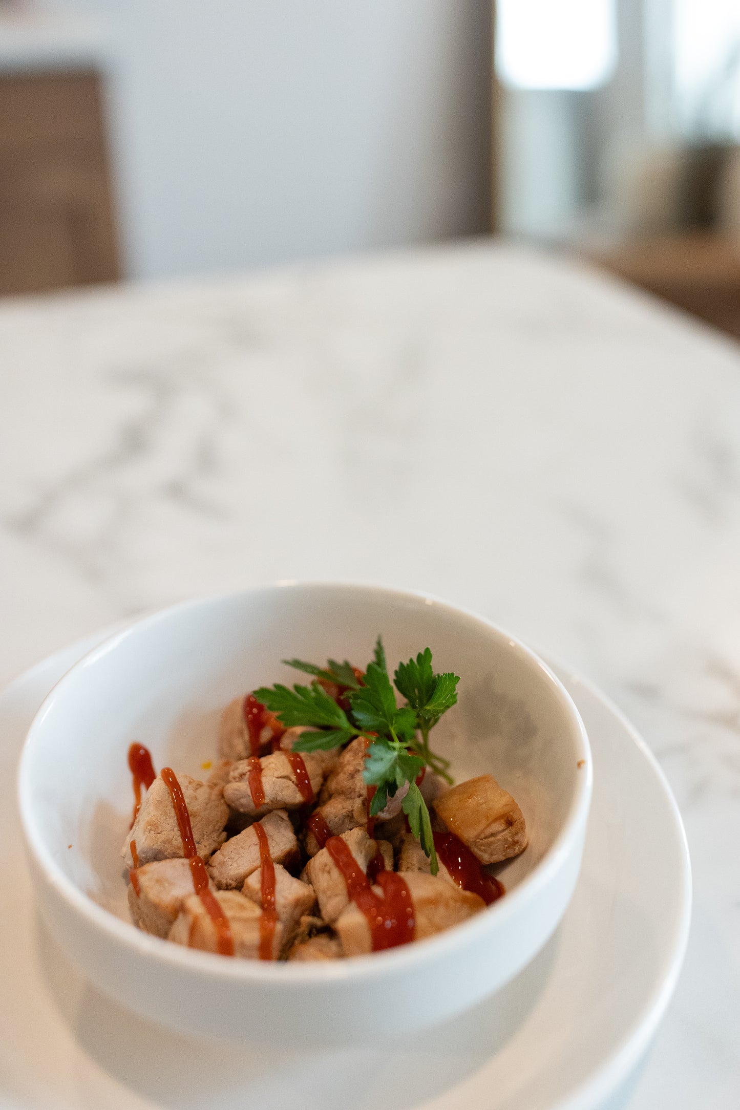 Cooked pork chops in a bowl drizzled with ketchup
