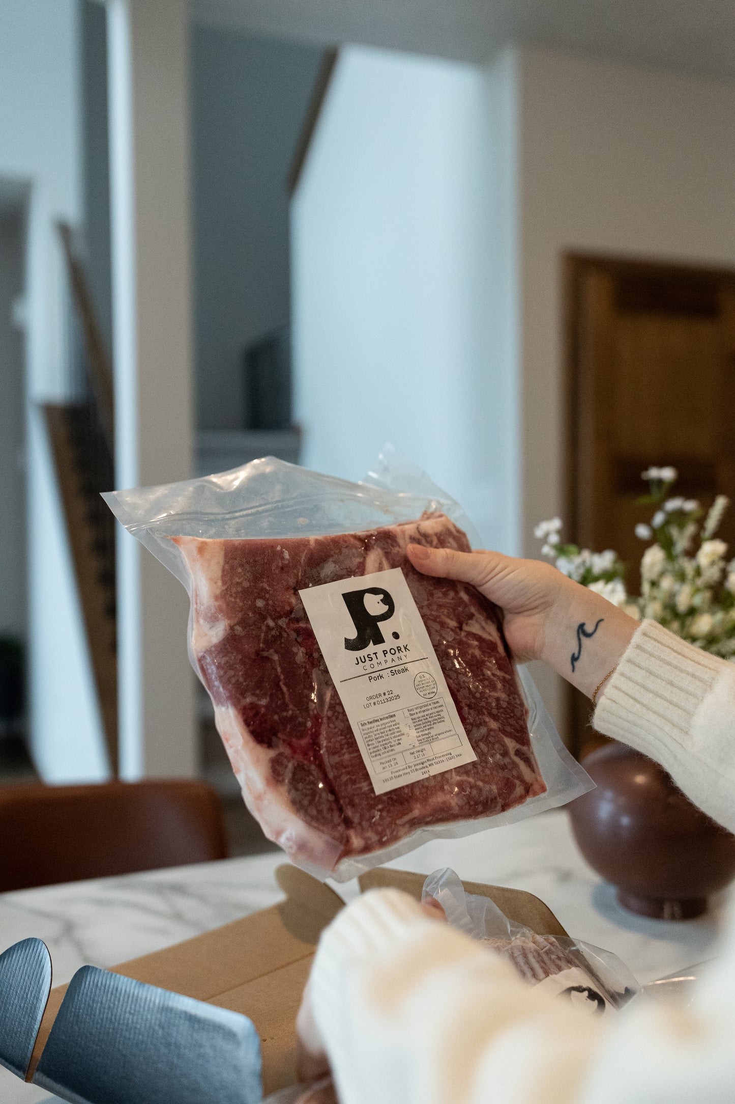 Women holding up a pork steak. Duroc pork steak showing rich color and natural fat