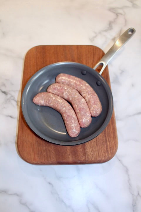 fresh pork brats in a pan; duroc-sired with an excellent source of protein. 