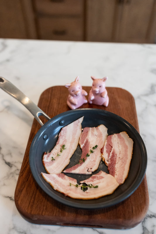 Slices of bacon in a pan; Fresh, well-marbled pork ready for your kitchen